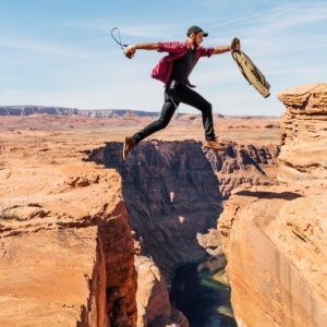 man jumping on rock formation